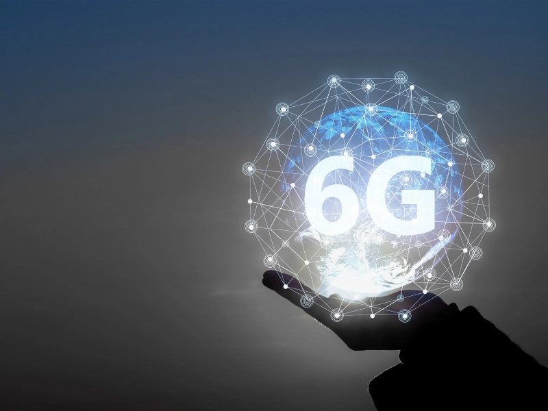 El üzerinde veri akışı ve kablosuz bağlantı sinyalleri ile 6G teknolojisini simgeleyen dijital illüstrasyon. Yüksek hız, düşük gecikme ve ileri düzey bağlantı konsepti görselleştirilmiş